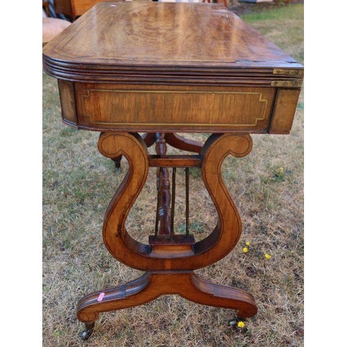 87 - A 19th century mahogany fold over tea table, raised on lyre ends, with inlaid brass and wood decorat... 