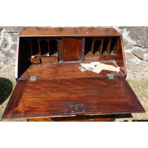 92 - An antique mahogany bureau, the sloping fall flap opening to reveal cupboards, drawers and pigeon ho... 