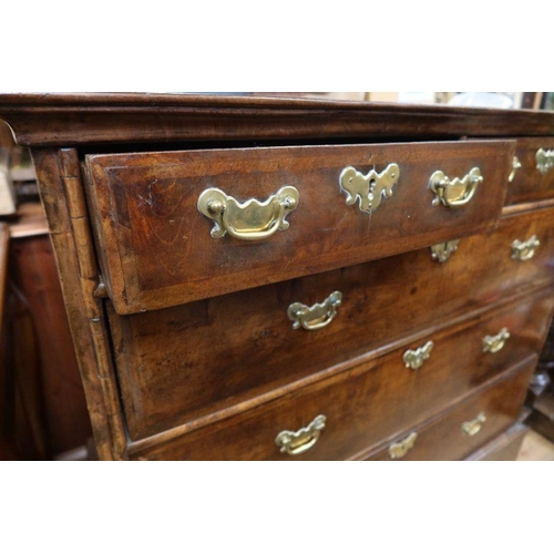 11 - An 18th Century walnut chest of drawers, having two short over three long drawers, raised on bracket... 