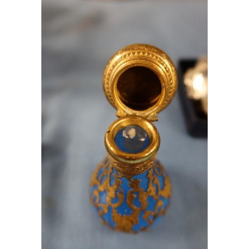 140 - A blue glass baluster shaped scent bottle, with gilt overlay scrolls, the gilt metal hinged top set ... 