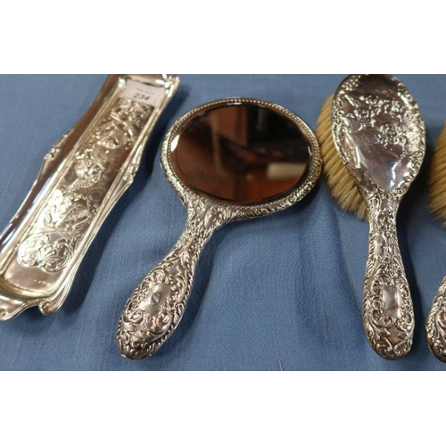 234 - A silver five piece dressing table set, decorated with cherubs, together with an oblong tray