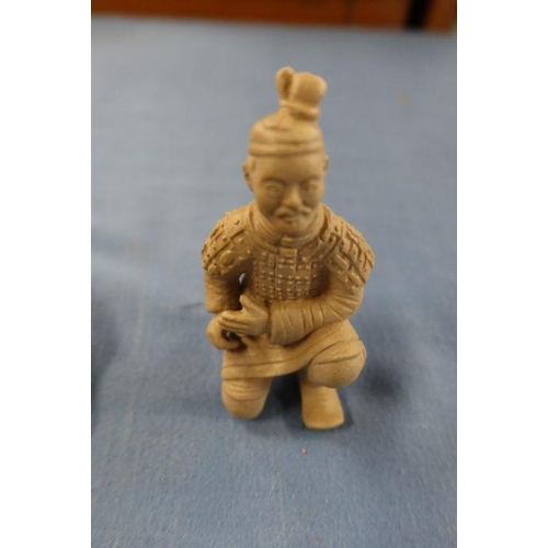 251 - A cloisonne bowl, on a wooden stand, together with a clay model of a kneeling figure