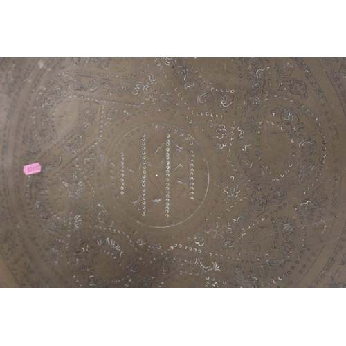 311 - A circular brass tray, with engraved decoration, diameter 23.5ins