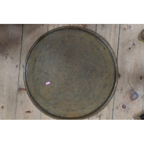 311 - A circular brass tray, with engraved decoration, diameter 23.5ins