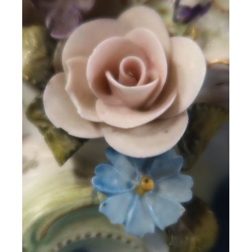 240 - A porcelain mantel clock, encrusted with flowers and two figures