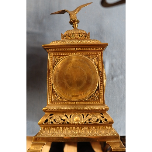 129 - A brass cased mantel clock, with eagle finial