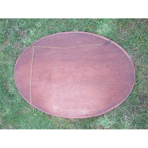 11 - An oval mahogany framed mirror, width 44ins