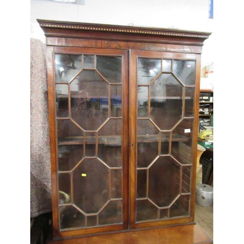 135 - A late Georgian mahogany bookcase cupboard, the upper section fitted with astragal glazed doors open... 