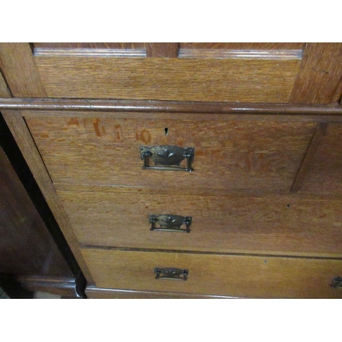 136 - An Arts and Crafts  light oak linen press, the two panel doors opening to reveal slide out trays,ove... 