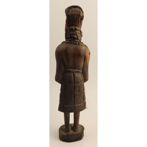 253 - A carved wooden African figure, together with another cast figure holding a shield