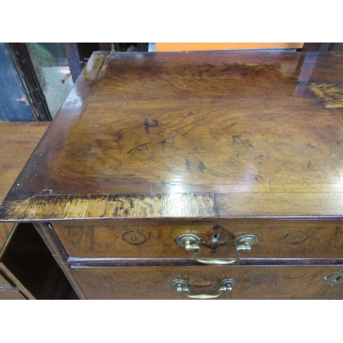 33 - An 18th century walnut chest on low stand,  having a quarter veneered cross banded top, over two sho... 