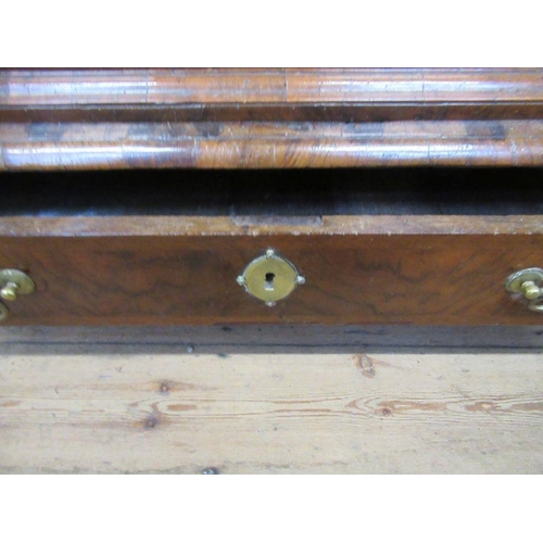 33 - An 18th century walnut chest on low stand,  having a quarter veneered cross banded top, over two sho... 