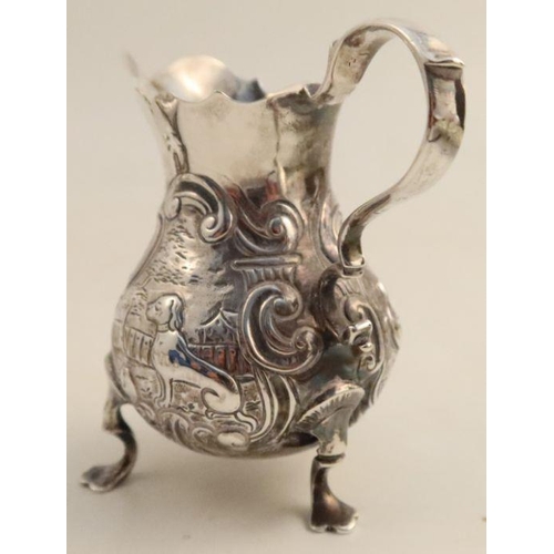 355 - A Georgian silver cream jug, of baluster form, the body embossed with scrolls, a hound and a bird, m... 