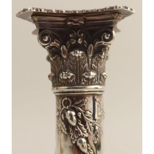 356 - A pair of silver candlesticks, with Corinthian capitals, embossed with swags of acorns and oak leave... 