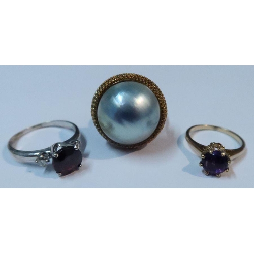 390 - A 14k garnet and diamond ring, together with a cabochon amethyst ring and a ring set with a pearl