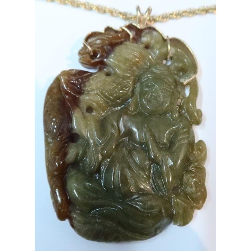 394 - A carved jade pendant, carved with a figure and dragon to one side and flowers to the other, on a 14... 