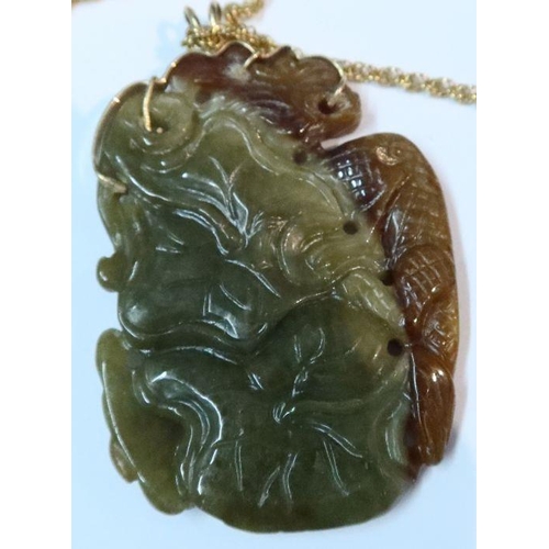 394 - A carved jade pendant, carved with a figure and dragon to one side and flowers to the other, on a 14... 