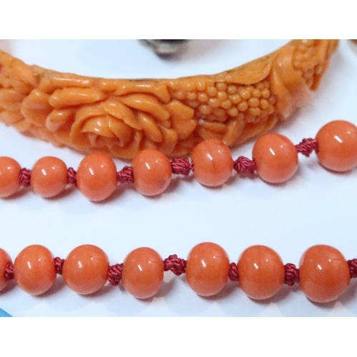 398 - A simulated coral necklace, together with a simulated coral bangle, a silver enameled butterfly ring... 