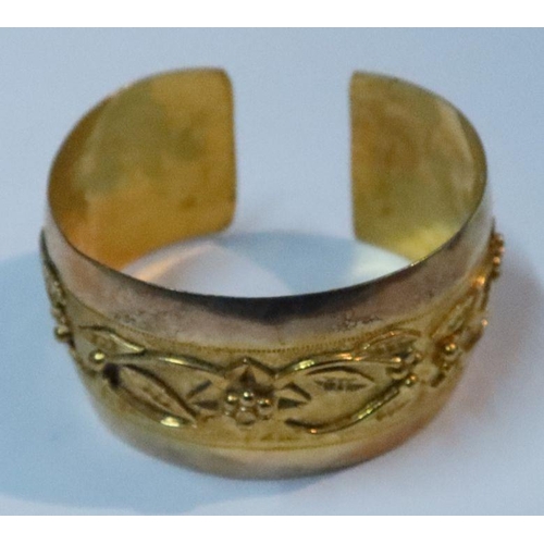 402 - A gold cuff bangle, with stylised raised frieze, 28g