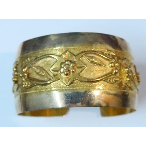 402 - A gold cuff bangle, with stylised raised frieze, 28g