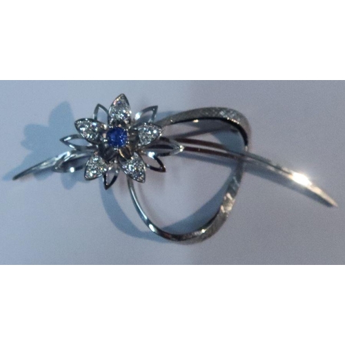 406 - An 18k white gold and floral spray brooch, the flower with central round cut sapphire and three grad... 