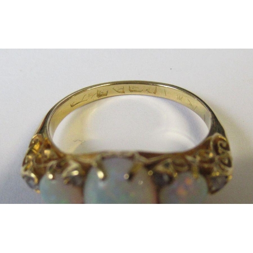 408 - An 18ct three stone opal ring with diamond accents, 3.9g