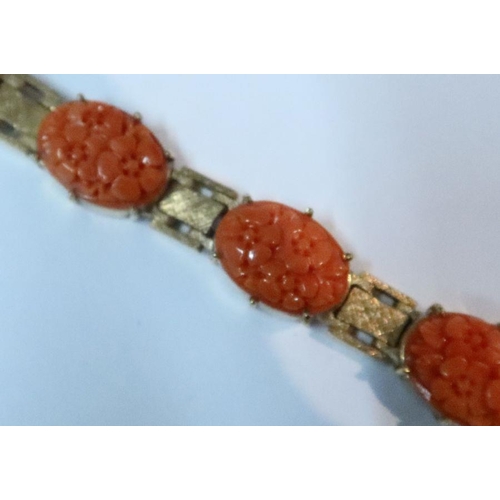 460 - A 9k gold and coral bracelet, with eight carved floral links, 21.3g