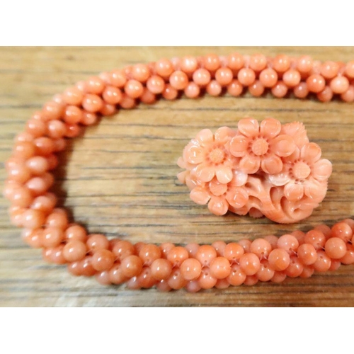 461 - A carved coral floral brooch, together with two coral rope necklaces and a pair of coral and pearl e... 