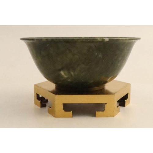 472 - A Chinese simulated spinach jade bowl, of circular form on gilt metal stand