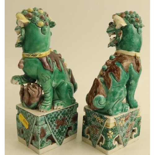 497 - A pair of Chinese famille vertes Shi Shi figures, raised on rectangular bases, height 7.5ins - One h... 