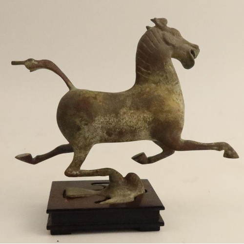 502 - A Chinese cast metal Tang dynasty style horse, in striding position on wooden base, height 6.5ins