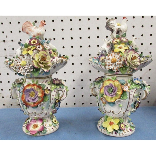 511 - A pair of 19th century porcelain candlesticks, decorated with rabbits and encrusted with flowers, he... 