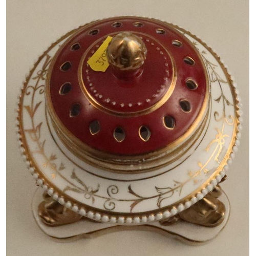 513 - A porcelain covered centre piece, the pierced cover decorated in burgundy and gilt, the body with re... 