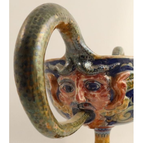 558 - A Cantagalli style pottery two handled pedestal cup, the interior decorated with putti picking apple... 