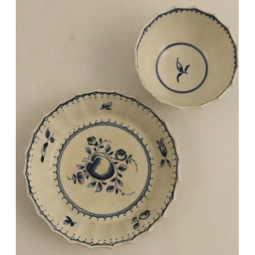 597 - A fluted Worcester tea bowl and saucer, painted in underglaze blue with fruit