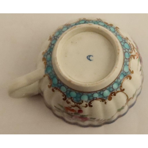 634 - A Worcester tea cup and saucer, the ribbed body decorated with flowers and garlands with a turquoise... 