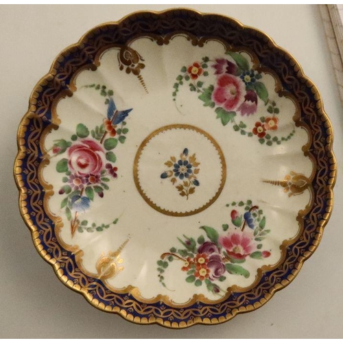 654 - A Worcester tea bowl, coffee cup and saucer, all fluted and all decorated with flowers to a dark blu... 