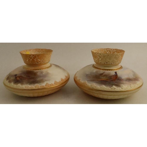 686 - A pair of Royal Worcester blush ivory vases, with pierced necks, the squat body painted with pheasan... 