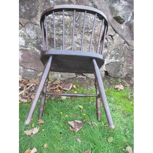 69 - A low stick back armchair, with elm seat and raised on turned legs