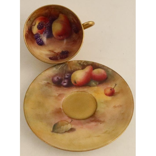 695 - A Royal Worcester cup and saucer, the interior of the cup and the saucer decorated with fruit to a m... 