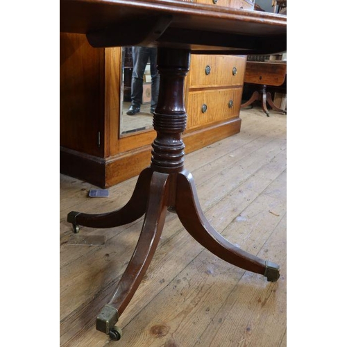 16 - A mahogany rectangular top table, raised on a turned column, with four outswept legs and brass caps,... 