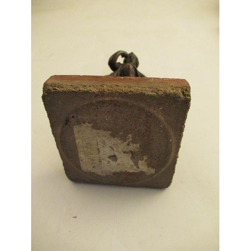 233 - A metal study of a figure by a seated lion raised on a square tile  height 7