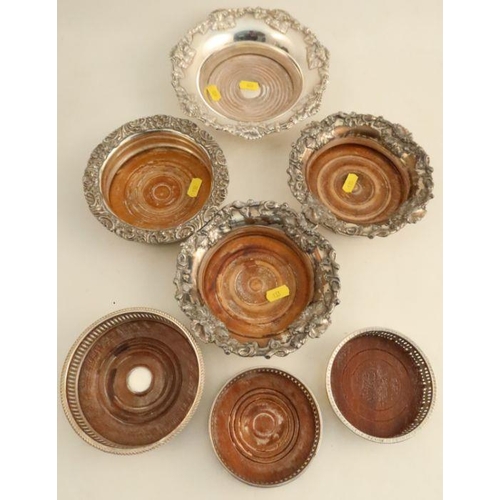 296 - Four silver plated bottle coasters, with embossed vine decoration, together with three silver plated... 