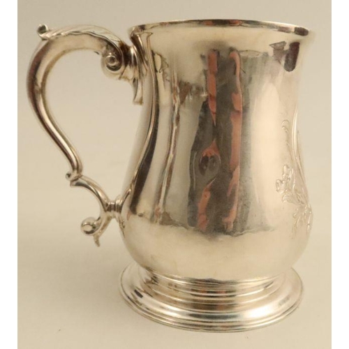 317 - A Georgian silver pint mug, with embossed decoration and engraved with a crest and initials, London ... 