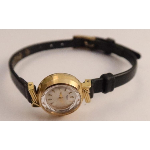 357 - A Tudor lady's gold cased wrist watch, the silvered dial with baton numerals, on black leather strap... 