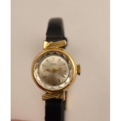 357 - A Tudor lady's gold cased wrist watch, the silvered dial with baton numerals, on black leather strap... 