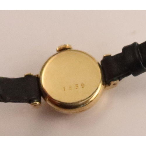 357 - A Tudor lady's gold cased wrist watch, the silvered dial with baton numerals, on black leather strap... 