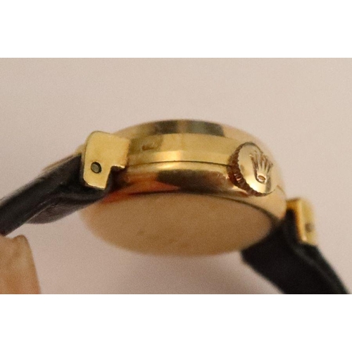 357 - A Tudor lady's gold cased wrist watch, the silvered dial with baton numerals, on black leather strap... 