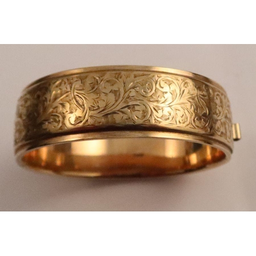 409 - A 9ct yellow gold hinged bracelet, engraved with leafage scrolls, Birmingham 1984, maker HB&S, weigh... 