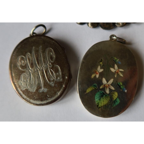 451 - Two lockets, one with enameled flowers, the other engraved with initials, together with a large silv... 